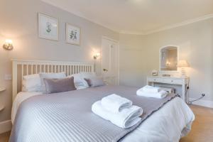 a bedroom with a large white bed with towels on it at 12 New Street in Padstow