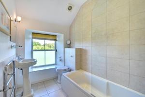 a bathroom with a tub and a toilet and a sink at St Teresas Cottage in Saint Mawgan +15 photos