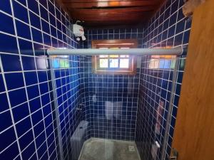 a bathroom with blue tiled walls and a window at Lindo flat Caxambu Vila Rica Pampulha in Venda Nova