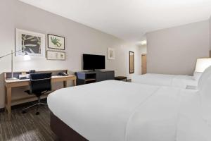 a hotel room with a bed and a desk with a computer at Country Inn & Suites by Radisson, Macon North, GA in Macon +60 photos