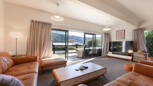 a living room with a couch and a tv at Koraha - Queen Charlotte Sound Holiday Home in Linkwater