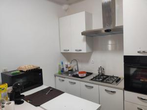a kitchen with white cabinets and a stove top oven at casa mara dakar in Bargny +15 photos
