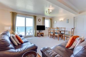Una sala de estar con un sofá y un comedor con una mesa. en Flat 11 Clifton Court, en Croyde