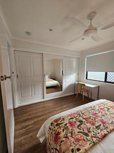 a bedroom with a bed and a desk and a mirror at Self-Contained 2BR Guest Suite with On-site Parking in Rochedale South