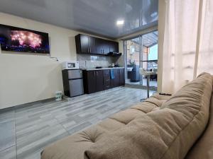 a living room with a couch and a kitchen at Acogedor & Exclusivo ApartaSuite cerca al centro comercial viva, unicentro y Uptc in Tunja +14 photos