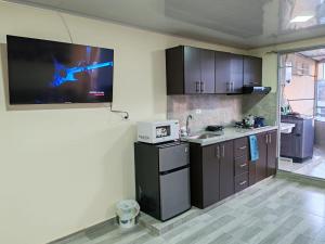 a kitchen with a tv hanging on the wall at Acogedor & Exclusivo ApartaSuite cerca al centro comercial viva, unicentro y Uptc in Tunja
