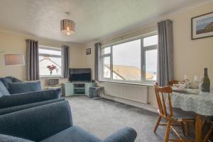 a living room with a couch and a table and a window at Carn Base in Sennen