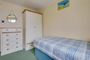a bedroom with a bed and a dresser and a cabinet at Carn Base in Sennen +12 photos
