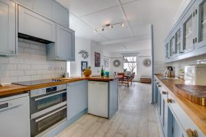 a kitchen with white cabinets and wooden floors at Pooh Corner in Praa Sands