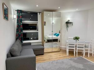 ロンドンにあるThe Finchley Grand Flat IIのソファのあるリビングルームとダイニングルーム