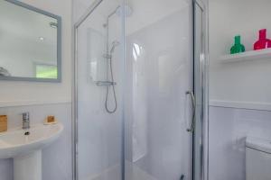a white bathroom with a shower and a sink at Pooh Corner in Praa Sands +22 photos