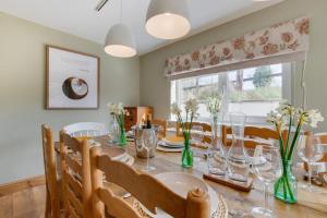 a dining room with a table and chairs and a window at Higher Treliver Farmhouse in Saint Wenn +19 photos