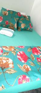 a bed with a blue comforter with flowers on it at Blackys 