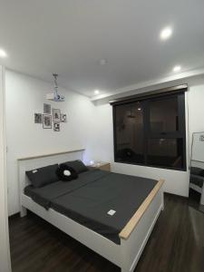 a bedroom with a large bed with a window at Romaji House in An Khê