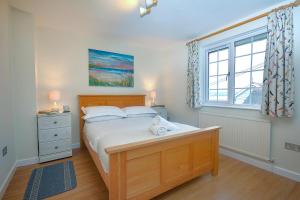 a bedroom with a large bed and a window at Harbour Cottage in Padstow