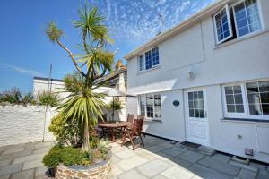 a house with a patio with a table and chairs at Harbour Cottage in Padstow