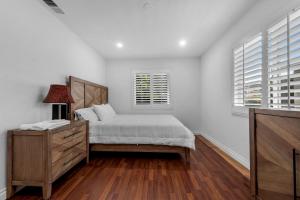 a bedroom with a bed and a dresser and windows at Modern Cali Comfort- Spacious 3BR Home Near Disneyland & Beaches in Midway City