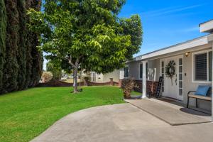 a house with a tree in the yard at Modern Cali Comfort- Spacious 3BR Home Near Disneyland & Beaches in Midway City