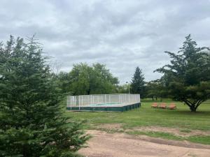 a swimming pool with two pink benches in a park at Depto Los Nidos 4 o 5 personas in Villa Cura Brochero