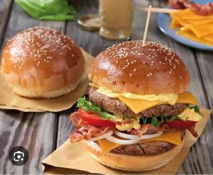 two hamburgers are sitting on a wooden table at Marina Hotel in Port Alberni