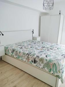 セジンブラにあるTijo Houseの白いベッドルーム(花柄のベッドカバー付)