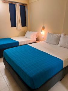 two beds sitting next to each other in a room at Alma Del Mar in Cartagena de Indias +8 photos