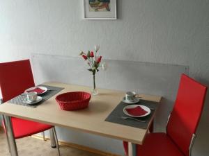 Una mesa de madera con un jarrón de flores encima. en Apartment Ilse Herbert, en Würzburg