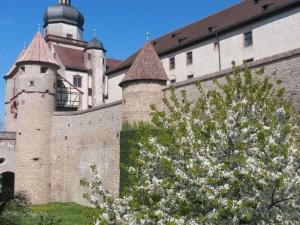 Un castillo con torretas y un edificio con un árbol. en Apartment Ilse Herbert, en Würzburg