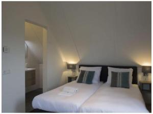 a bedroom with a white bed with two pillows at Holiday home with 2 bedrooms in Veere