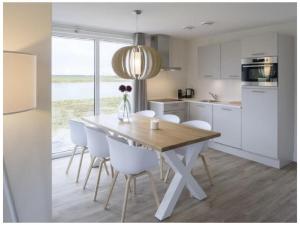a kitchen with a wooden table and white cabinets at Holiday home with 2 bedrooms in Veere +7 photos