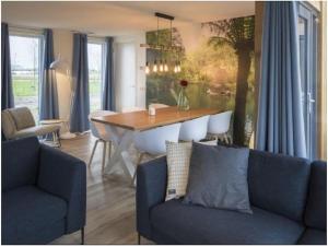 a living room with a table and a blue couch at Holiday home with 2 bedrooms in Veere