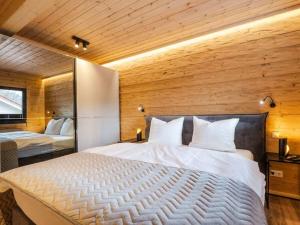une chambre avec un grand lit et des murs en bois dans l'établissement Bergwaldchalet Animal Friend 2, à Schierke