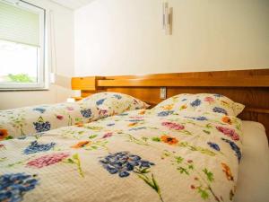ein Bett mit geblümter Bettdecke und zwei Kissen in der Unterkunft Holiday apartment with 2 bedrooms in Monschau