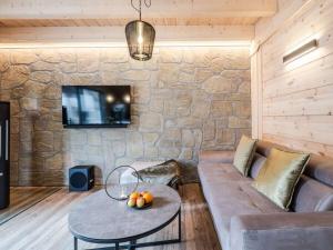 a living room with a couch and a stone wall at Mountain Forest Chalet Comfort 4 in Schierke