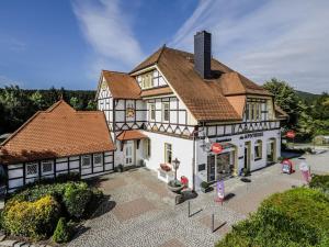 a large white building with a brown roof at Mountain Forest Chalet Comfort 4 in Schierke