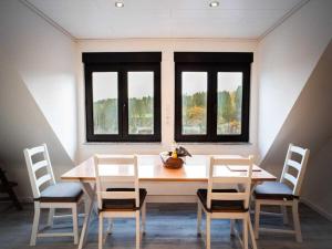 ein Esszimmer mit Tisch und Stühlen und Fenstern in der Unterkunft Holiday apartment with 2 bedrooms in Monschau