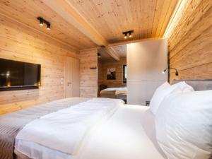 a bedroom with two beds and a flat screen tv at Mountain Forest Chalet Comfort 4 in Schierke
