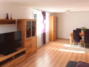 a living room with a flat screen tv and a table at Holiday apartment with 3 bedrooms in Enzklösterle