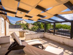 Holiday home in Gabonjin with swimming pool في Gabonjin: فناء به كراسي بيضاء و شمسية على سطح