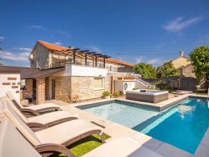 Holiday home in Gabonjin with swimming pool في Gabonjin: مسبح وكراسي ومنزل