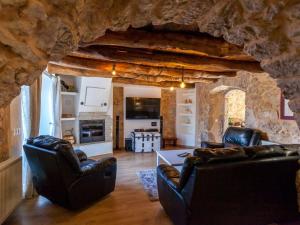 Holiday home in Gabonjin with swimming pool في Gabonjin: غرفة معيشة مع أثاث جلدي وجدار حجري