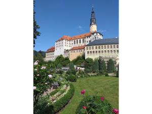 a large building with a garden in front of it at Holiday home with 2 bedrooms in Naundorf
