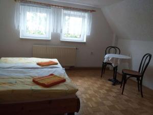 a bedroom with a bed and a table and chairs at Holiday home with 2 bedrooms in Naundorf