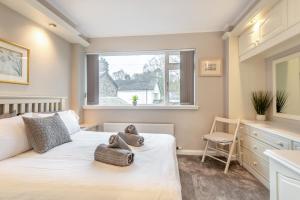 une chambre avec un lit avec un ours en peluche dessus dans l'établissement Mews Cottage, à Grasmere