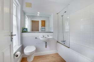 Un baño blanco con inodoro y lavabo. en Aquarius, en Saint Levan 13 fotos más