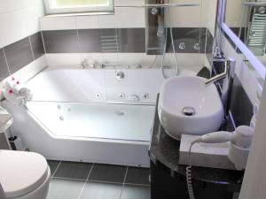 łazienka z wanną, umywalką i toaletą w obiekcie Maarhöhe in the Maarberg Resort w mieście Schalkenmehren +35 zdjęć