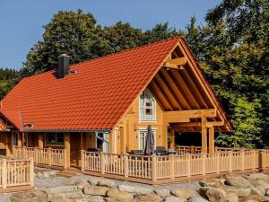 Una casa con techo naranja, porche y terraza. en Bergwaldlodge Blickfang, en Schierke 14 fotos más
