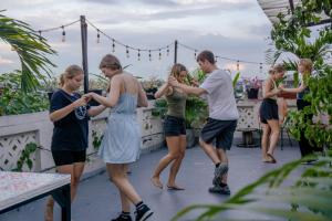 een groep mensen die op een balkon staan en met hun telefoons spelen bij La Palmera Hostel in Cali