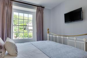 Un dormitorio con una cama y una ventana grande. en Memories Cottage, en Milnthorpe