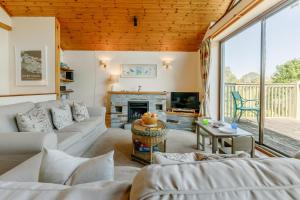 Una sala de estar con sofás y chimenea. en Milton Lodge, en Little Petherick
